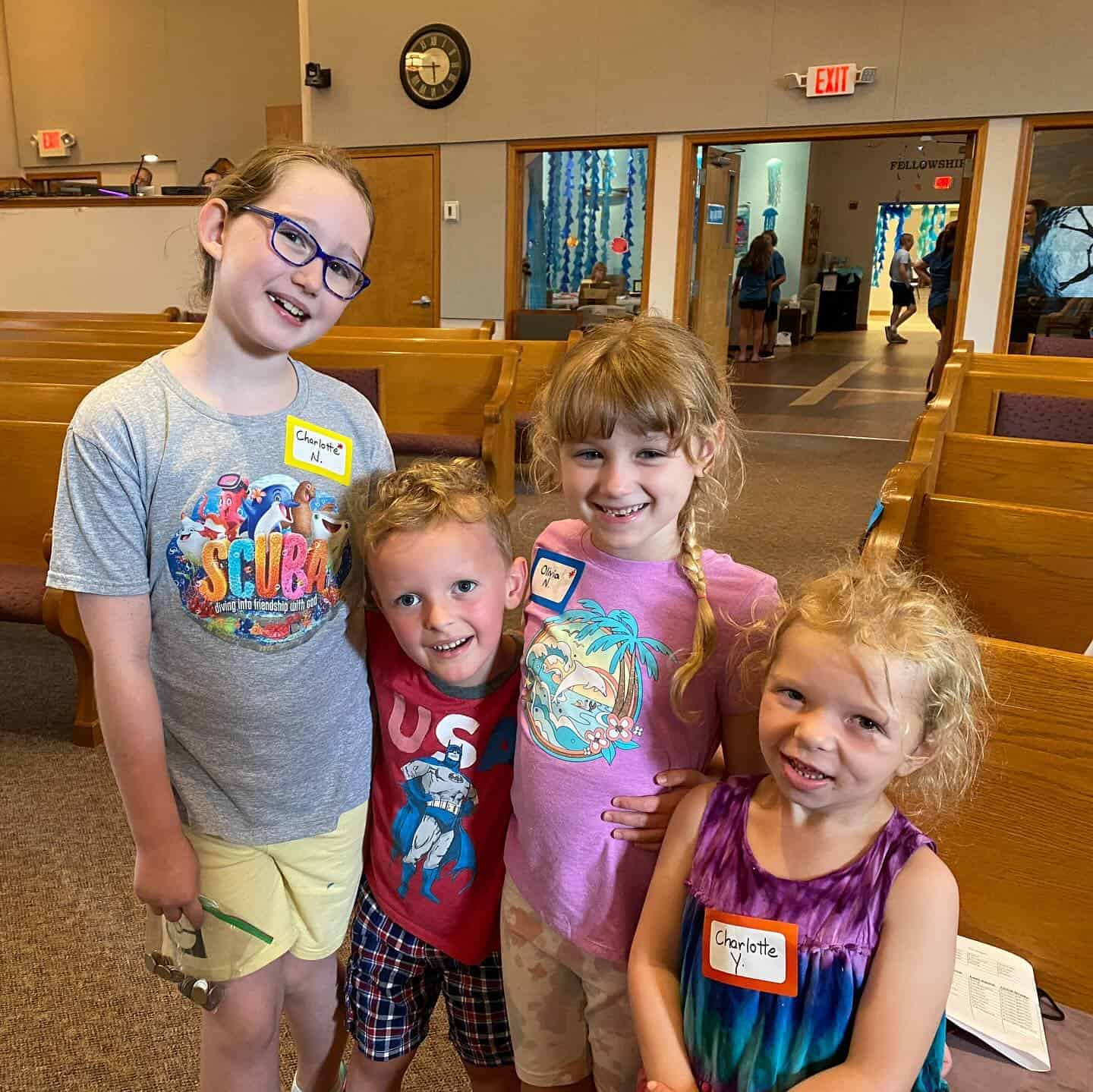 Four children smiling in a church room.