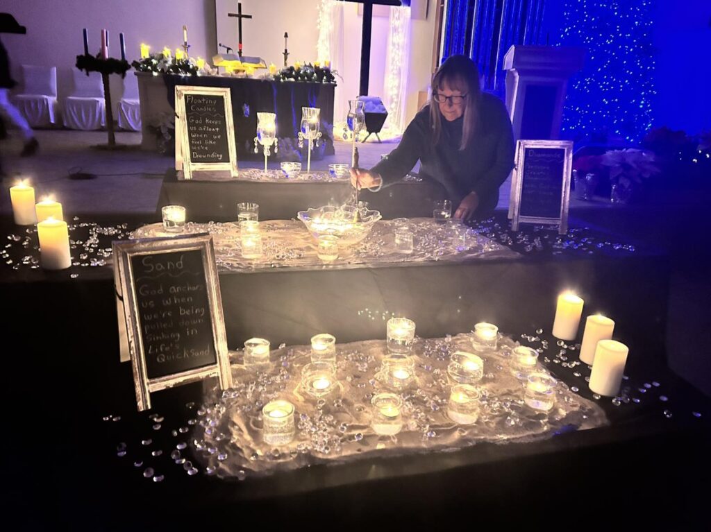 Person lighting candles in decorated church altar