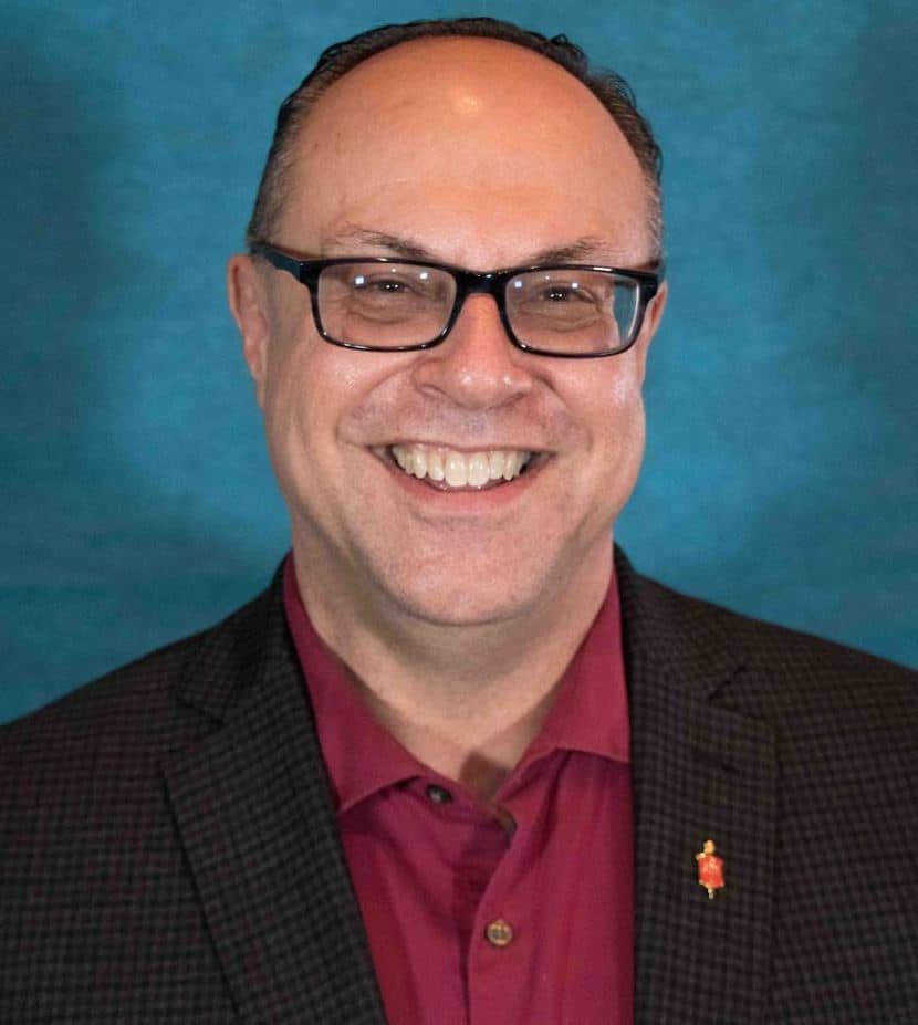 Smiling man with glasses against blue background