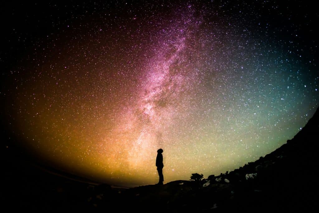 Silhouette under vibrant Milky Way night sky