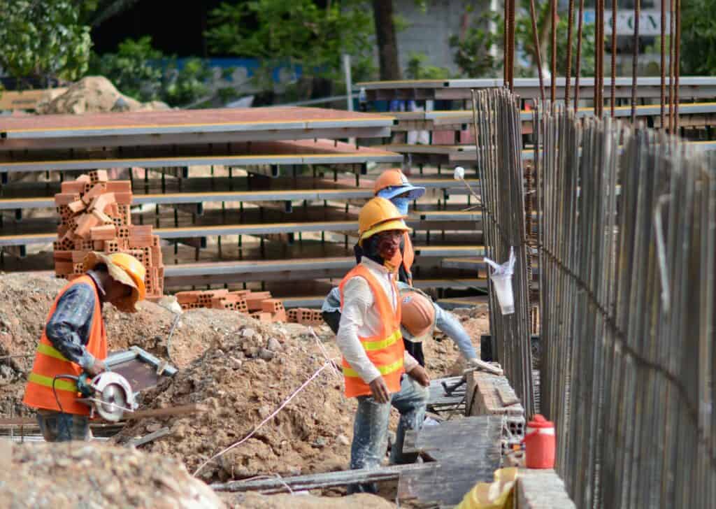 Construction workers installing rebar at building site